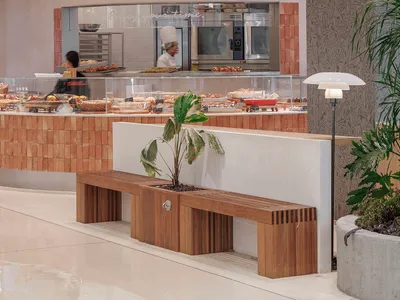 A modern restaurant interior featuring concrete, tile, and glass materials.