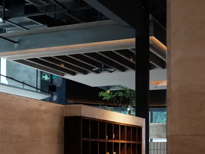 A modern restaurant interior featuring wooden shelves and warm lighting.