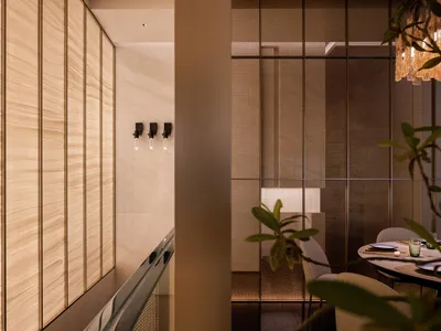 Interior of a minimalist restaurant featuring glass walls and a modern dining setup.