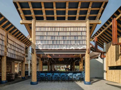 Bamboo roof and metal framed restaurant bar with seating area