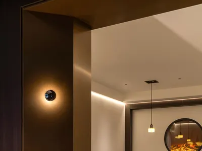 A modern restaurant interior with concrete walls and wooden booths.
