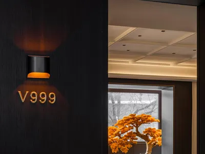 Modern restaurant interior with wooden elements and orange accents.