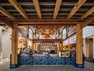 Modern coffee shop interior featuring a wooden bar and blue tiled flooring.
