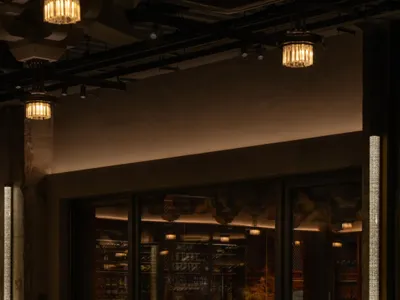 A minimalist restaurant interior featuring black glass tables and modern furniture.