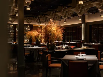 Modern restaurant interior with metal, wood, and glass materials.