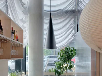 A minimalist restaurant interior featuring concrete bars and tables.