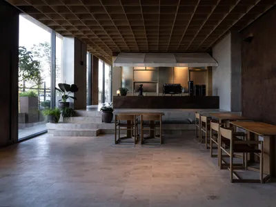 Interior design of a modern restaurant with concrete materials and industrial aesthetic.
