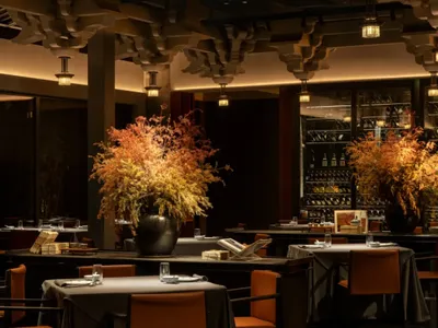 A modern restaurant interior with concrete, glass, and minimalist design elements.