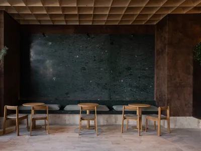 A modern restaurant interior with stone seating area and minimalist design.