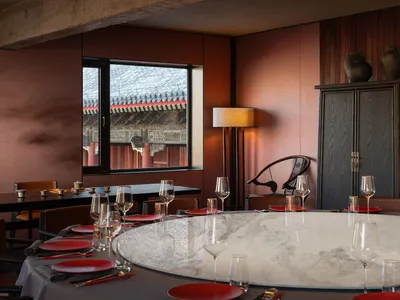 Modern restaurant dining room with marble tables and red accents