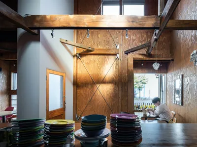 現代餐廳室內以木質材料打造，搭配懸掛燈具。