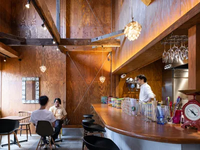 Interior view of an industrial-themed restaurant featuring wooden walls and furniture.