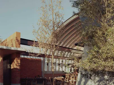 A modern restaurant exterior with concrete walls and a tree in the center of a paved area.