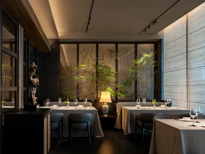 A well-lit, contemporary restaurant interior with modern furnishings and decor, featuring sleek tables, chairs, and wall-moun