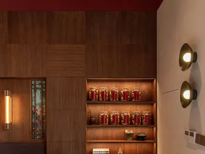A modern restaurant interior with wooden furniture and shelves filled with jars.
