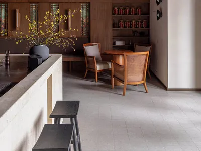 A modern restaurant interior with wooden walls and terrazzo flooring.
