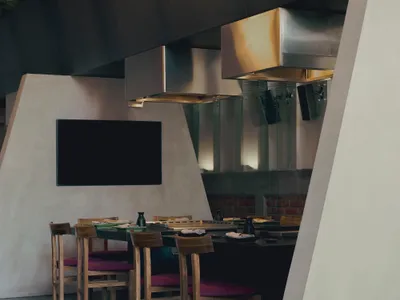 Modern kitchen with sleek metal countertop and stools.