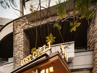 Outdoor seating area at a modern restaurant with wooden furniture and a stylish sign.