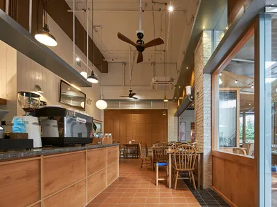 A cozy coffee shop interior with wooden furnishings, glass windows, and metal details.