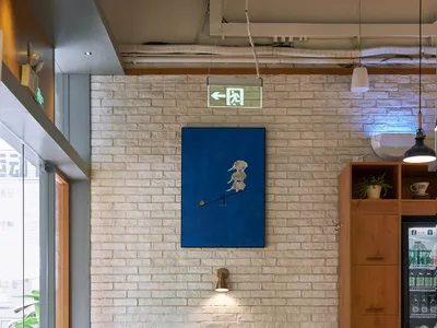 A cozy cafe interior with brick walls, wooden furniture, and tiled seating area.