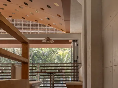 Modern restaurant interior with wood and concrete materials and brown floor tiles