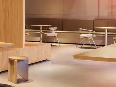 Modern restaurant interior with wooden tables, chairs, and benches.