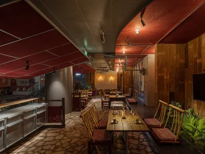An industrial-style restaurant interior featuring wood, stone, and metal elements.