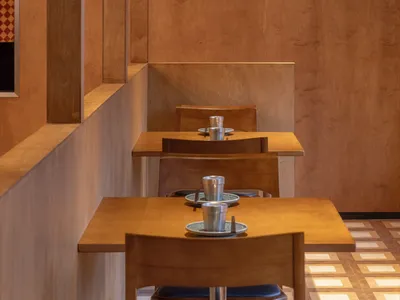 A modern restaurant interior featuring wooden panels and seating