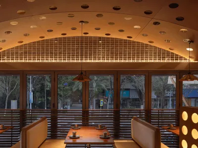 A modern restaurant interior featuring wooden materials.