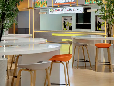 Modern restaurant interior with wooden tables and glass partition