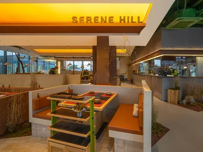 A modern restaurant interior featuring concrete and wooden elements.