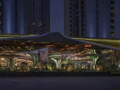 A modern restaurant with a glazed exterior at night, featuring sleek lines and led lighting.
