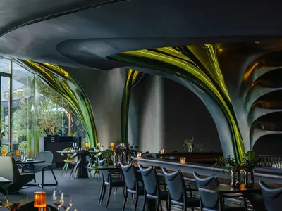 Modern restaurant interior featuring green acrylic design elements and contemporary seating.
