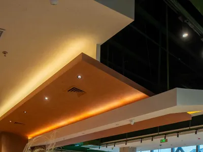 A modern restaurant interior featuring concrete walls and wooden seating.