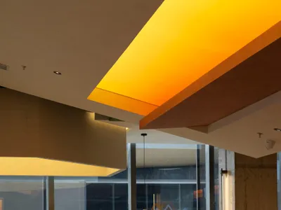 A modern restaurant interior featuring warm lighting and wooden elements.