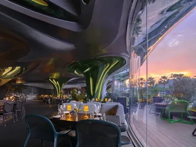 A modern restaurant with metallic decor features sleek, curved fixtures for contemporary dining experience.