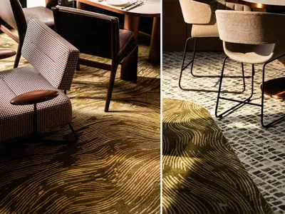 A modern restaurant with patterned carpet, featuring contemporary chairs and tables.