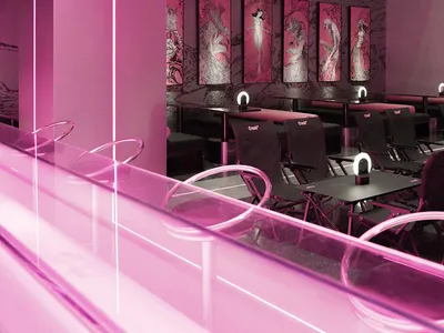 Industrial-style restaurant interior featuring metal tables, glass railings, and pink lighting