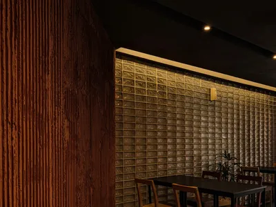 Modern restaurant interior featuring glass brick walls and wooden chairs