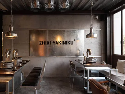 Industrial-style restaurant interior featuring metal and concrete materials, with seating and grills.