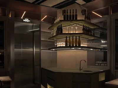 Interior of an industrial-themed restaurant bar featuring metal and wooden elements
