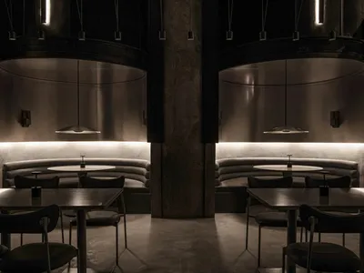Industrial-style restaurant interior featuring metallic elements and modern seating.