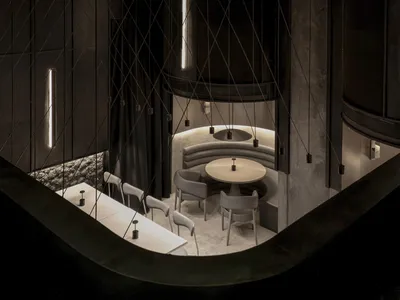 Modern cafe interior with metal columns, concrete walls, and glass panels