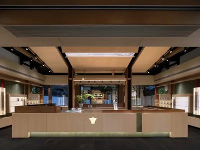 現代餐廳室內設計，採用混凝土地板、木製餐桌及玻璃展示櫃。