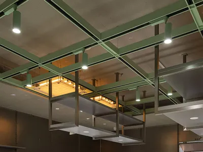 現代商用廚房，配有金屬操作台、玻璃層架，以及綠色斑點地板。