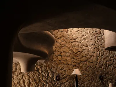A dimly lit industrial restaurant bar with stone walls and wooden furnishings.