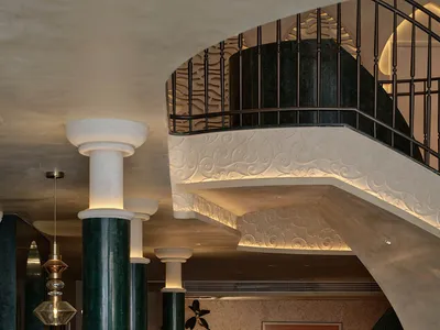 A modern hotel reception area with marble columns and a reception desk.