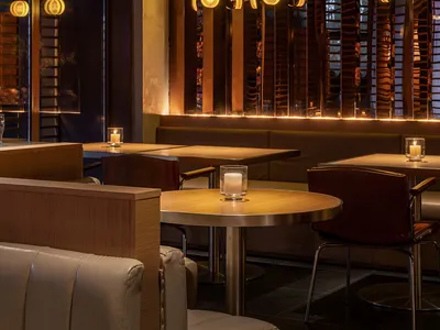 Modern bar interior with wooden accents and warm lighting.