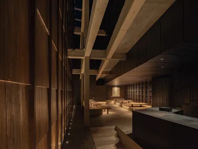 A modern restaurant interior featuring concrete and wooden elements.
