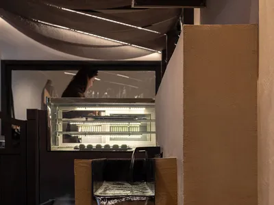 Modern Japanese restaurant interior with wooden accents, concrete walls, and glass accents.